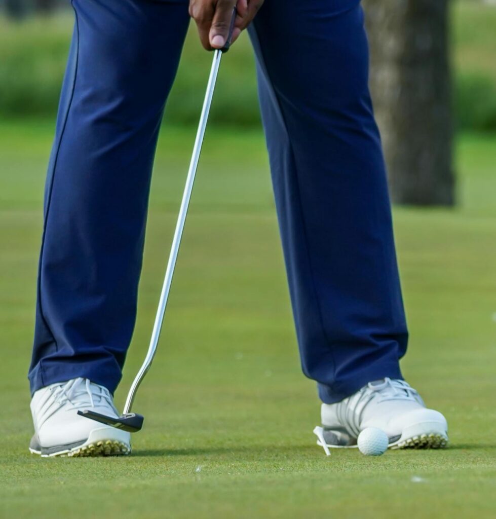 person positioning a golf club